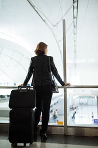 Business Frau mit Aktentasche und Koffer am Flughafen
