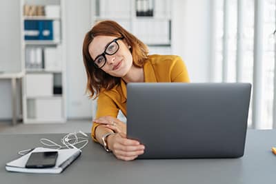 Frau arbeitet am Tisch mit Laptop